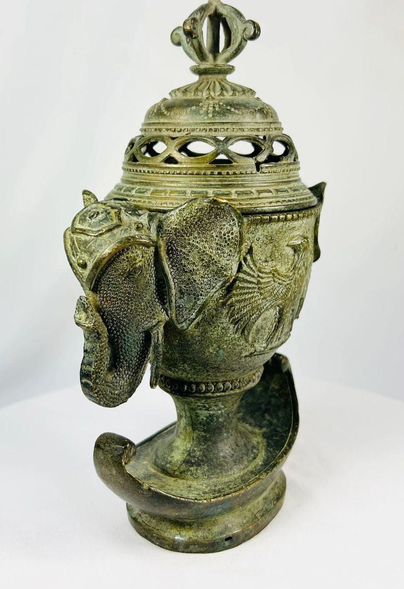 Qing Dynasty bronze censer with elephant-head handles, phoenix motifs, and vajra finial on a white background.