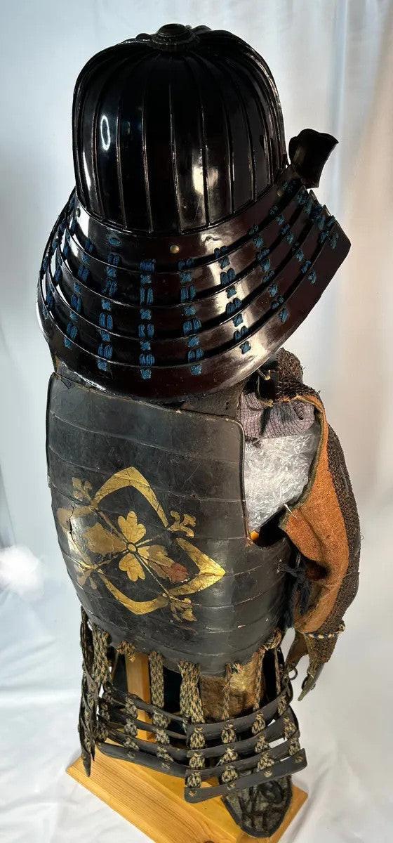 Right rear angle of Muromachi Samurai armor set with black lacquer kabuto, Edo-period silk cords, and gold-detailed cuirass on display stand.