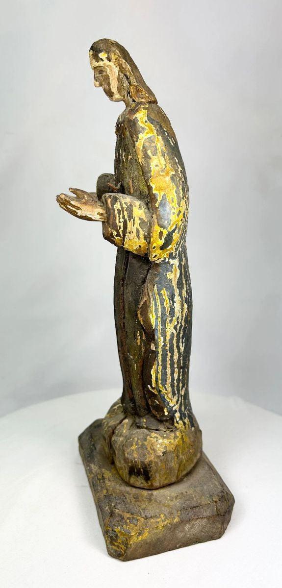 Close-up of a Spanish Colonial santo hand-carved wooden statue displaying surface wear and age