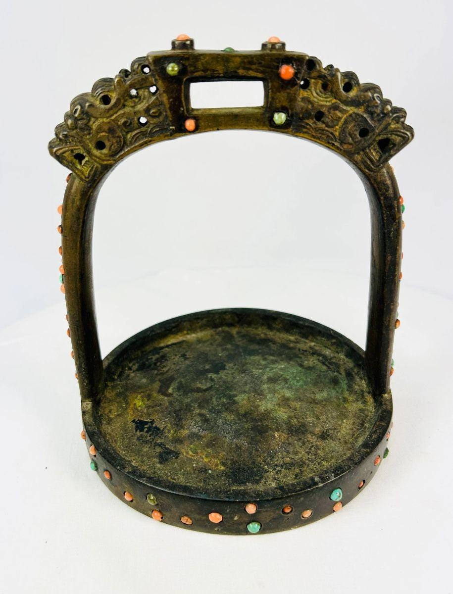 Historic 18th–19th century bronze stirrup with dragon-head terminals, photographed against white backdrop.