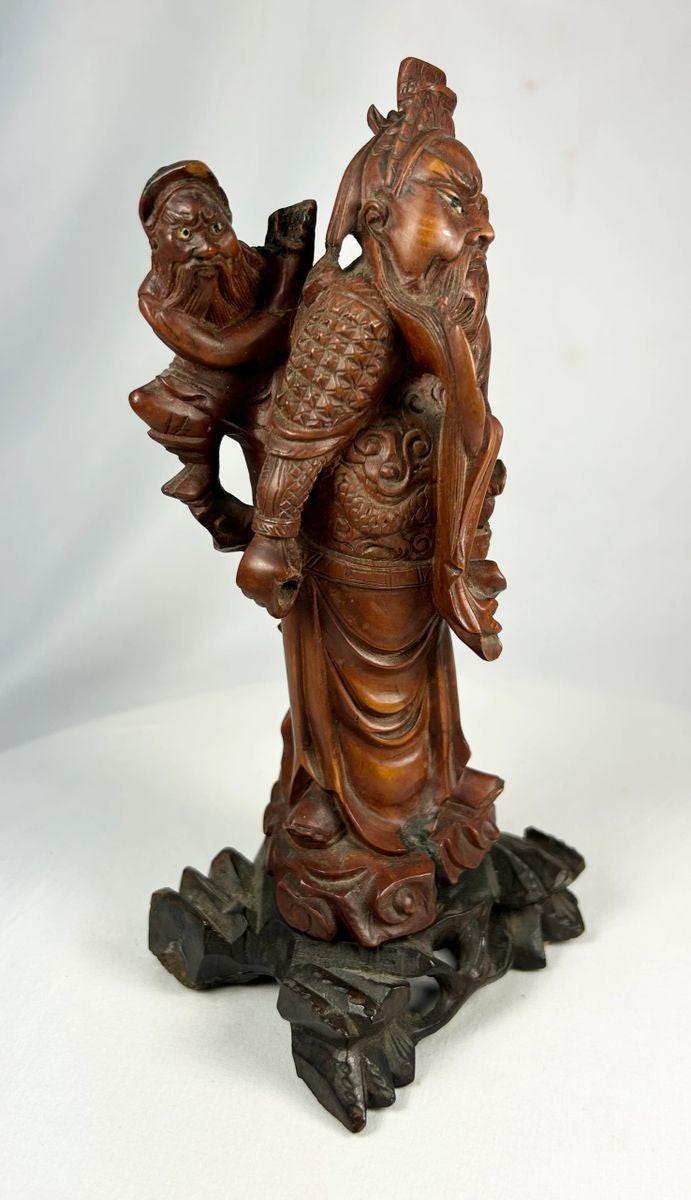 Chinese hardwood carving of warrior immortal with symbolic weaponry