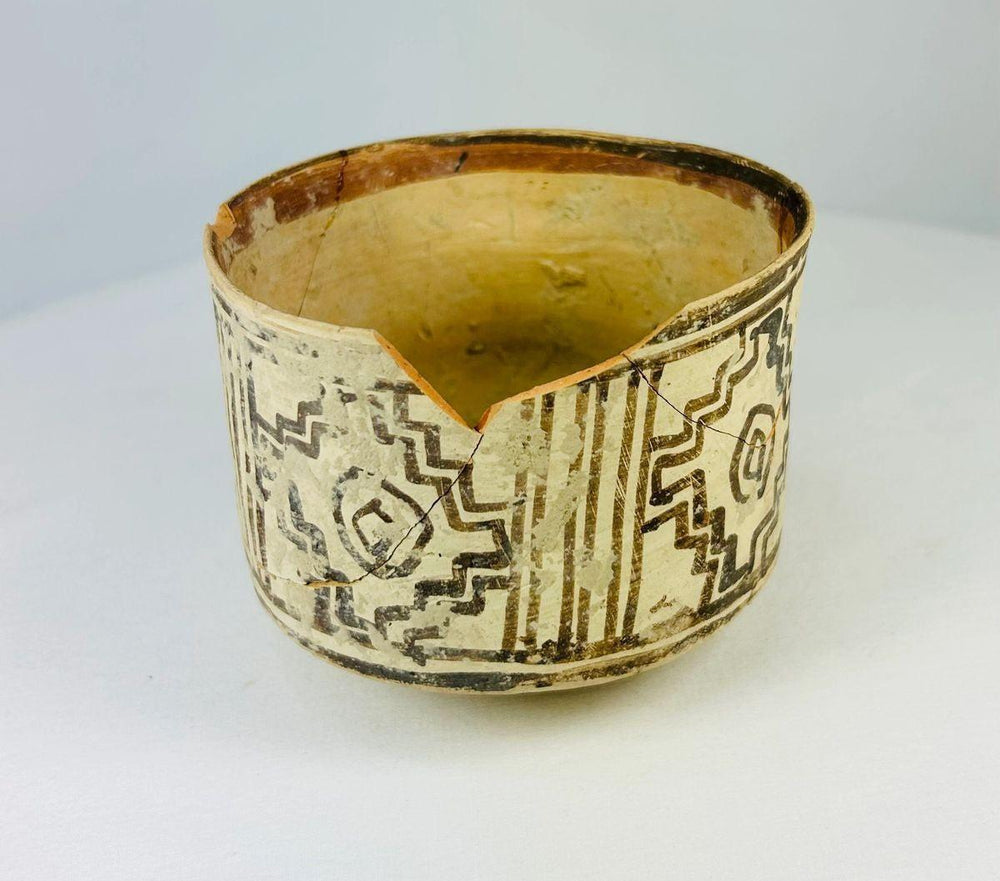 Ancient Harappan ceramic vessel showing cylindrical form and symbolic painted decoration.
