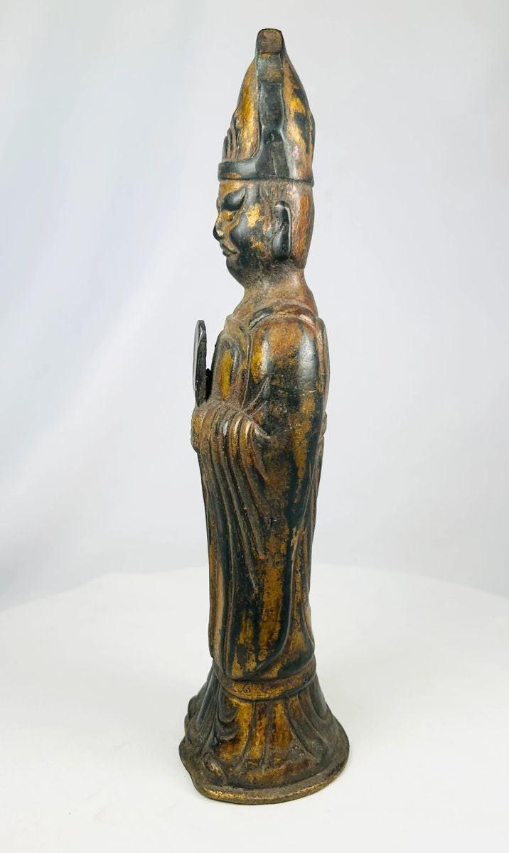 Close-up of gilt bronze Tibetan Lama figure with ritual object in hand