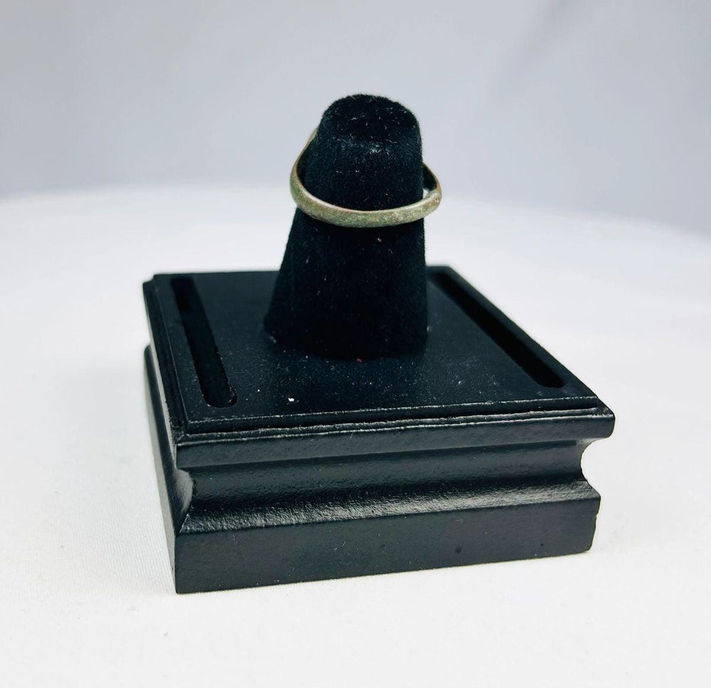 Museum-style display of ancient bronze ring with elephant motif, early symbolic jewelry