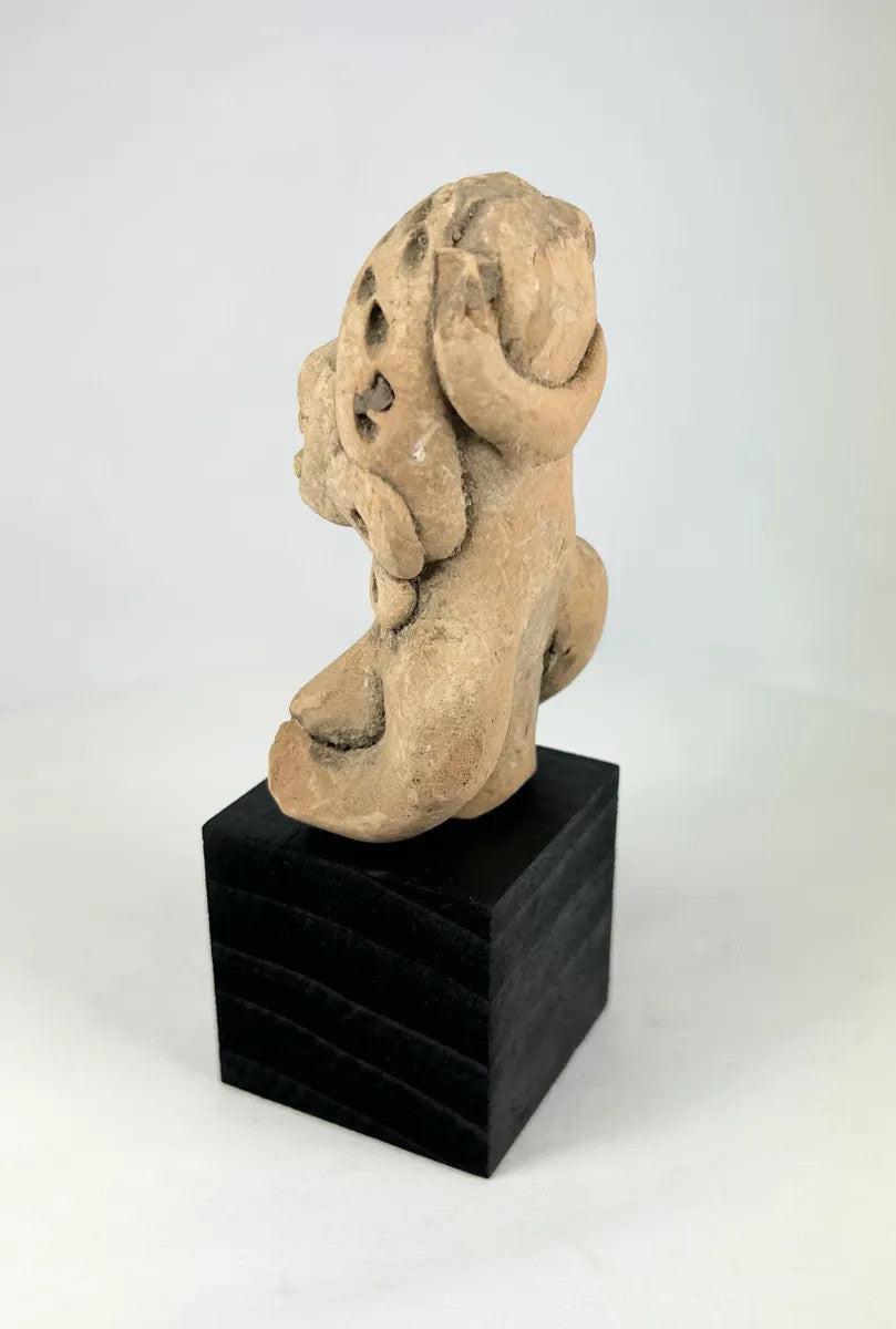 West Mexican terracotta funerary figurine showing a seated woman with pierced eyes and earspools