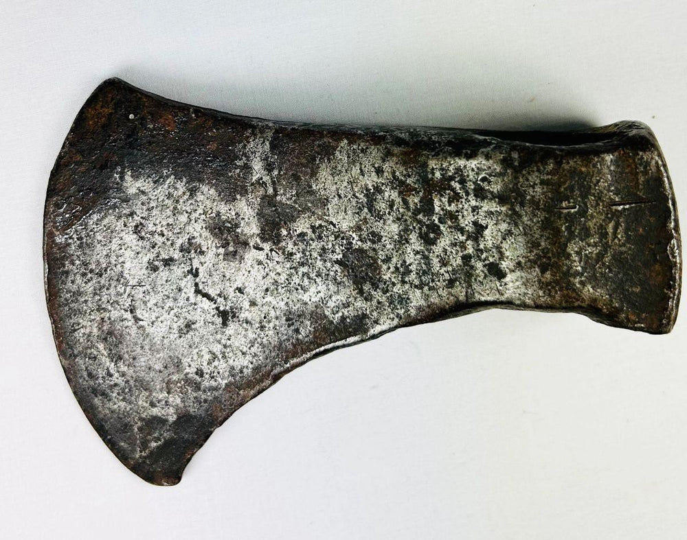 19th-century frontier-era hand-forged iron axe head showing tapered cutting edge and aged patina