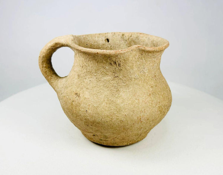 Ancient terracotta single-handled vessel with rounded body and flared rim