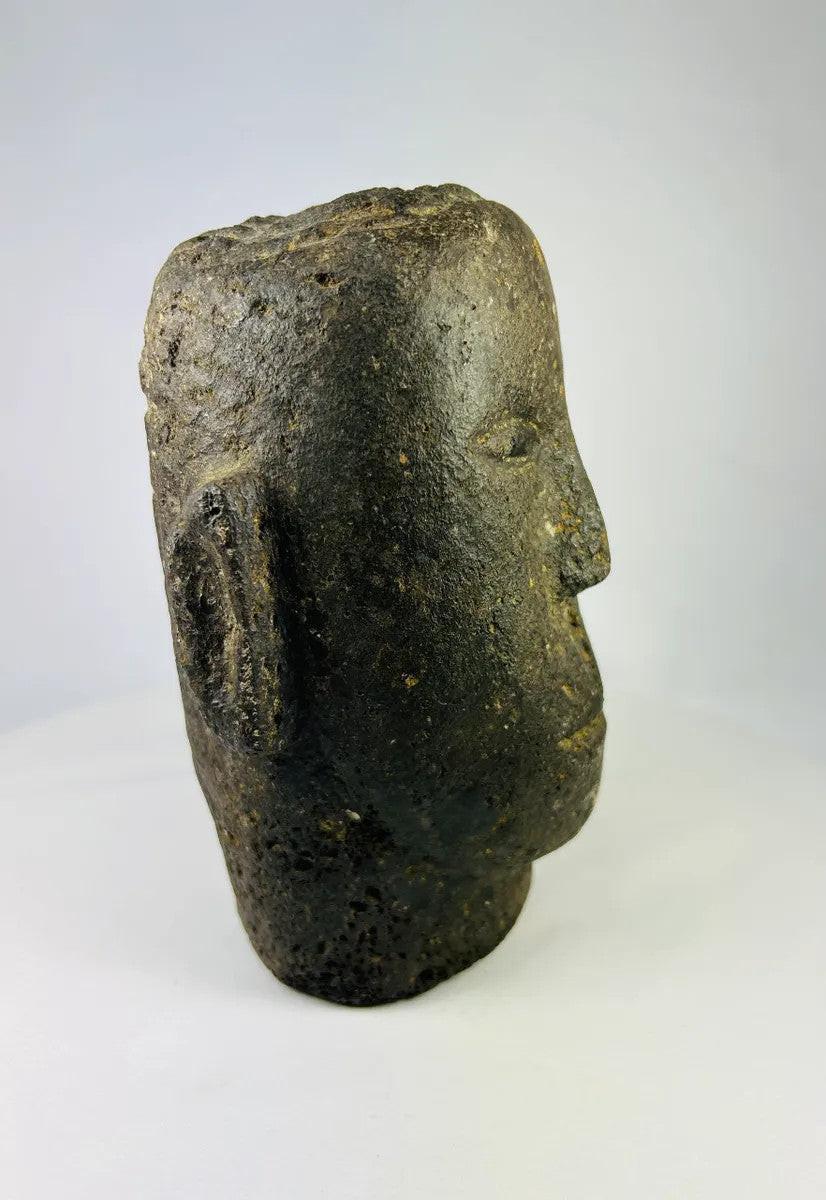 Angled view highlighting the shape and carving of an antique Polynesian volcanic stone head.