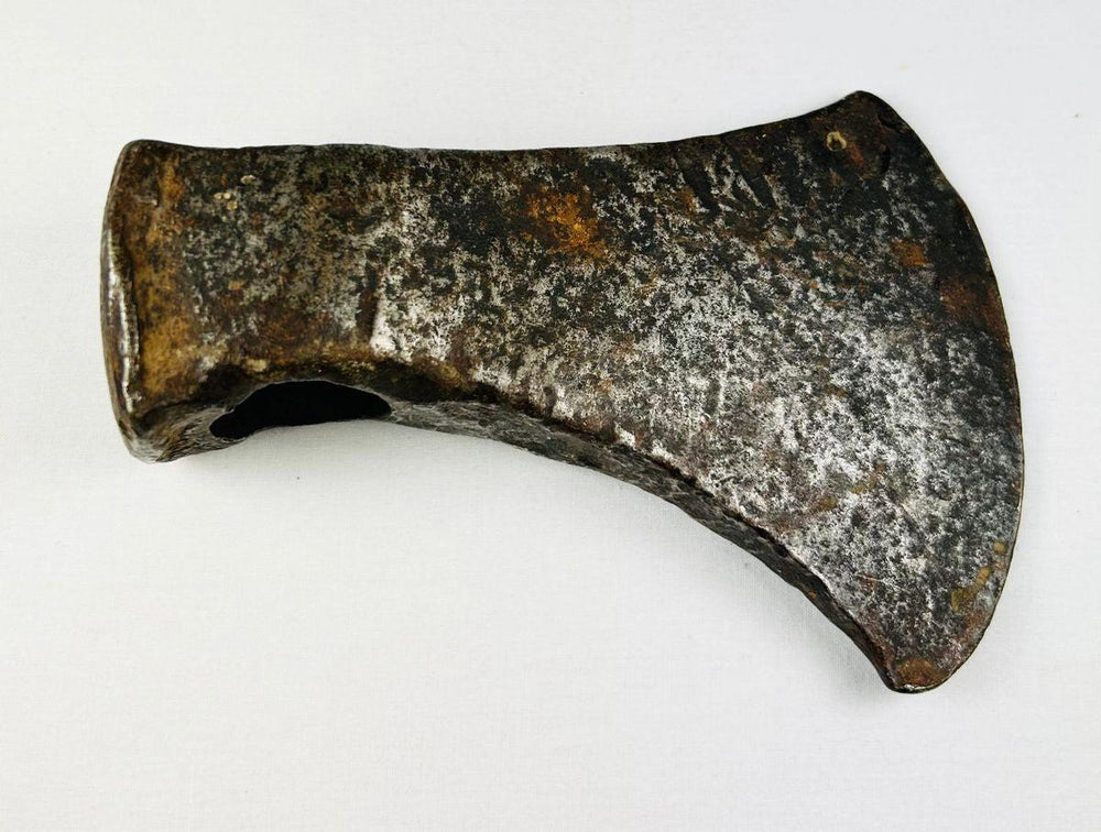Historic North American axe head from the 1800s displaying forged eye socket and rustic tool craftsmanship.