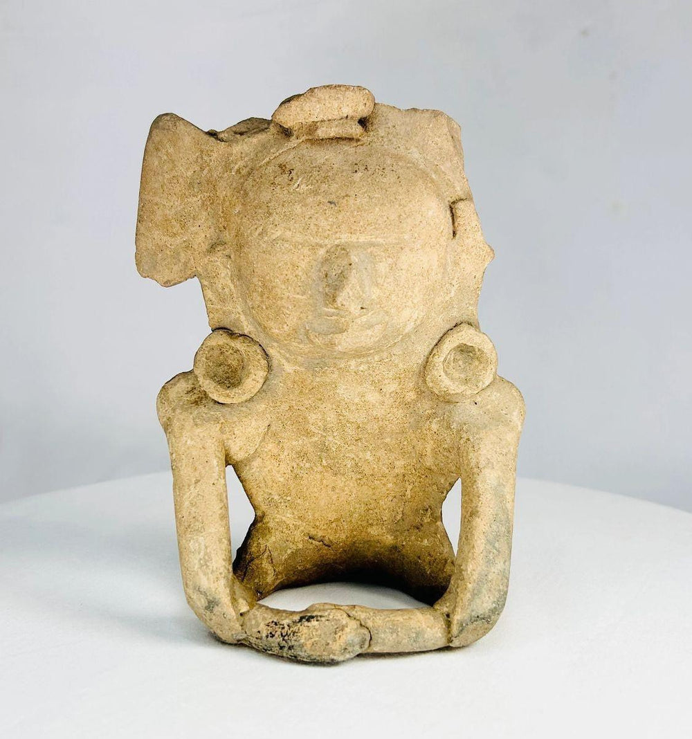 Antique Mesoamerican terracotta ritual figurine with helmet-like headpiece and ear spools, dating to 200–800 AD