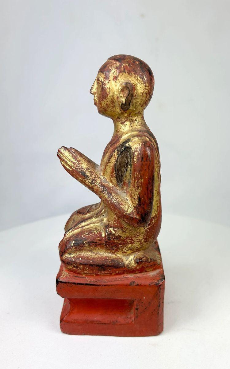 Side profile of 18th–19th century Burmese monk statue showing carved robes and aged lacquer surface.