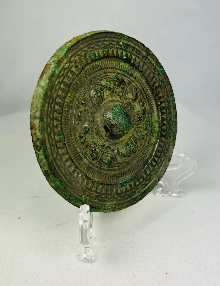 Ancient Chinese bronze mirror from the Han Dynasty featuring detailed patterns and a well-developed green patina.