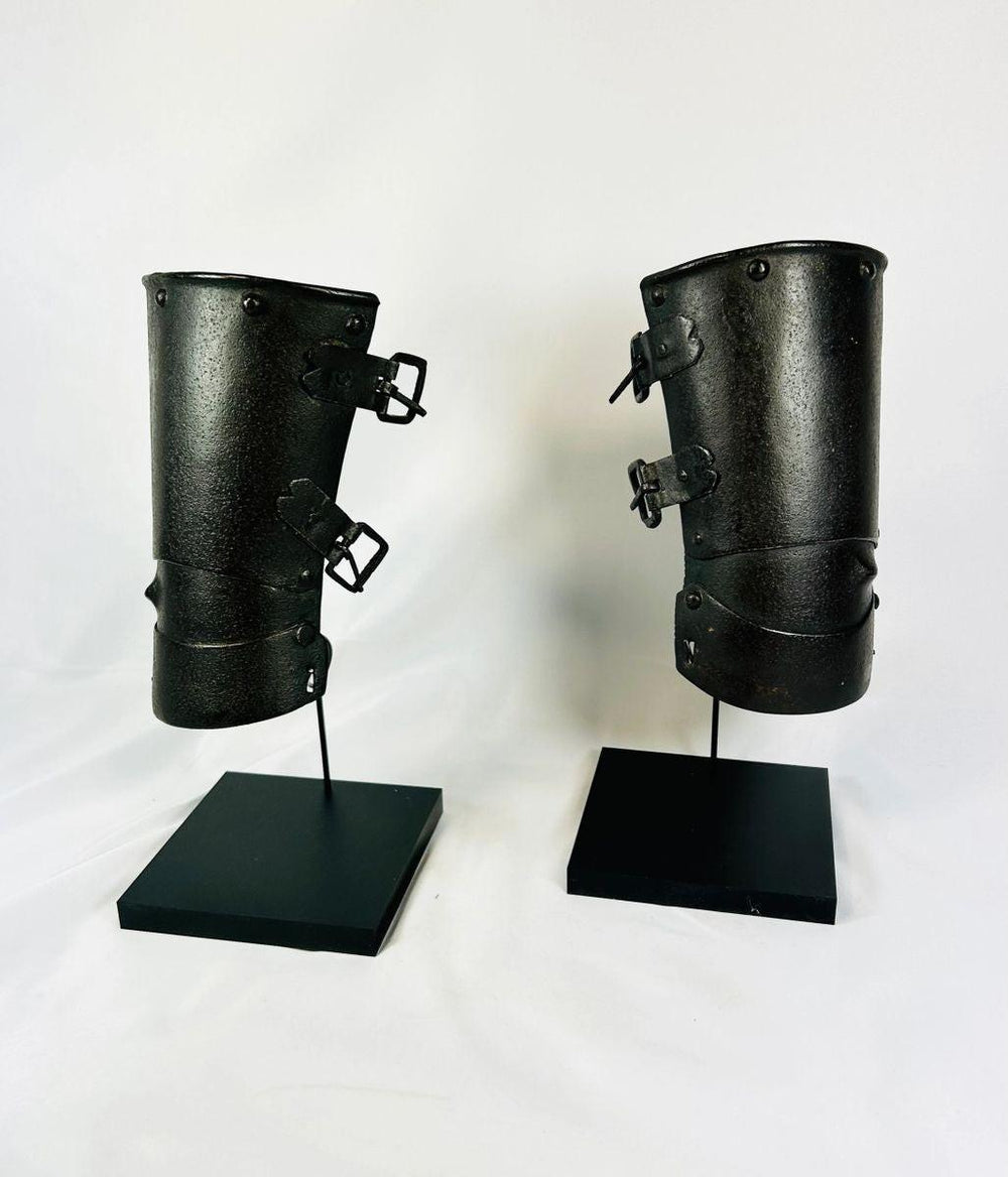 Pair of 15th–16th century Continental armour vambraces, medieval European steel forearm guards with riveted plates displayed on black stands, Relic and Rarity.
