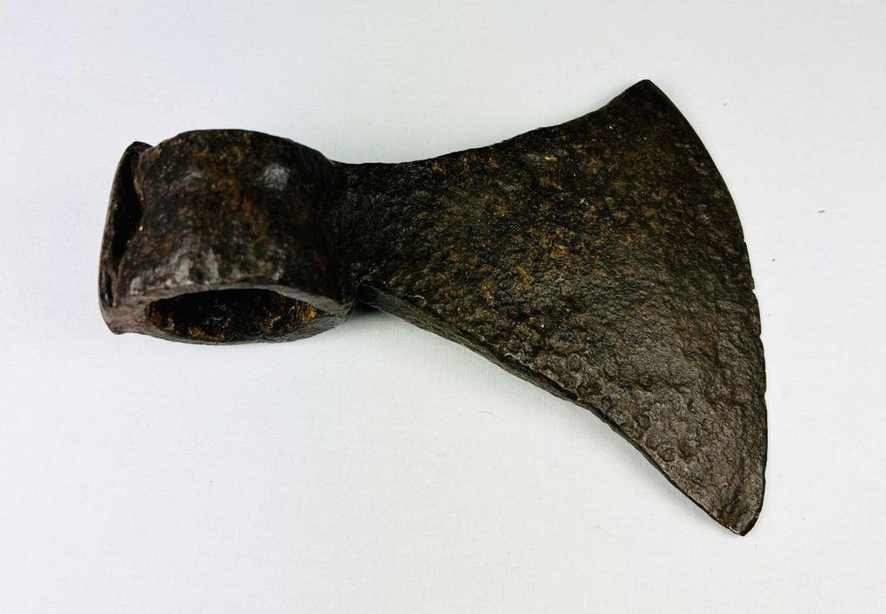 Historic forged iron axe head from the American frontier displaying craftsmanship and natural aging.