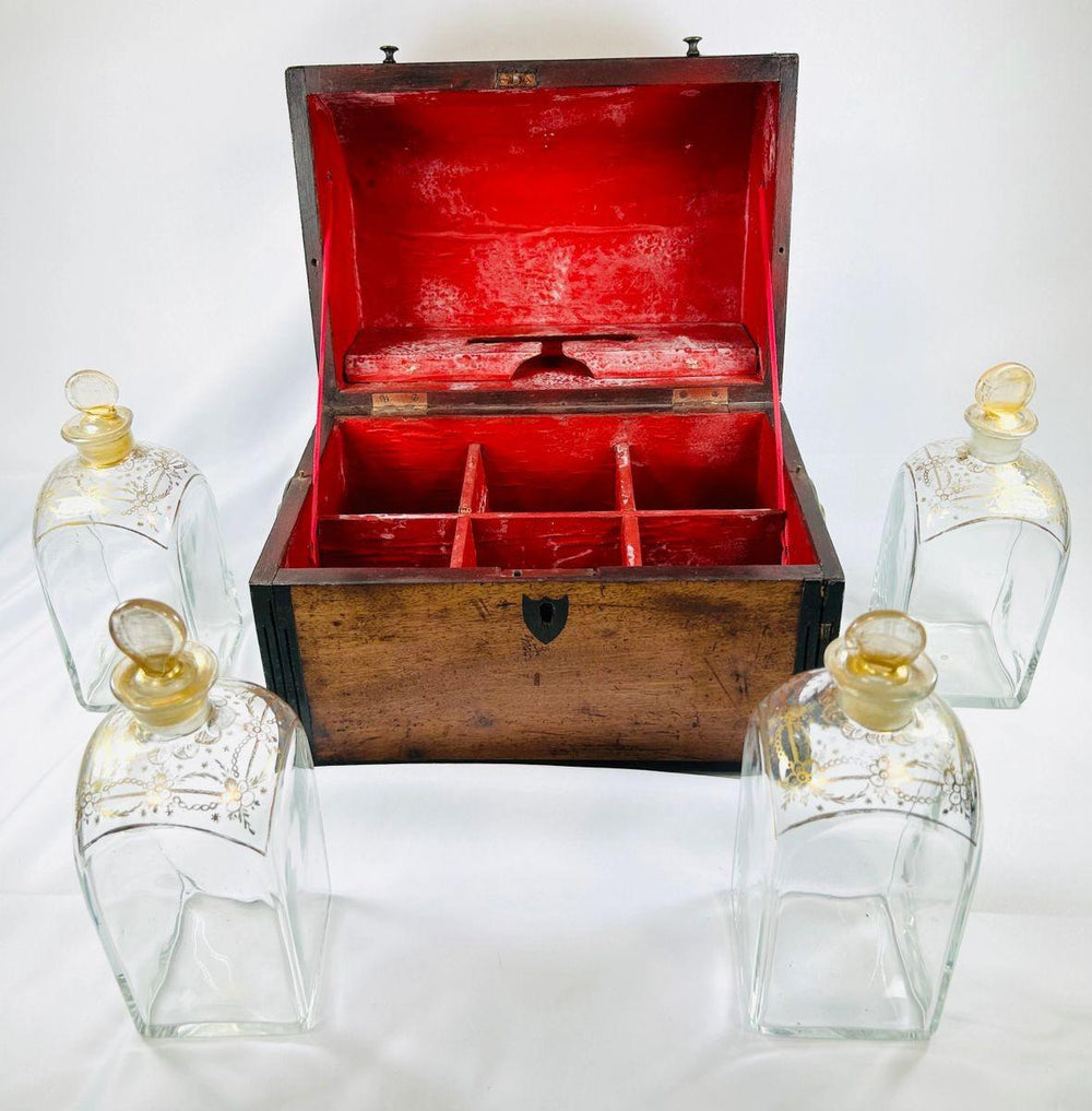 Early Georgian spirit box with red-lined interior shown open, surrounded by four matching gilt-decorated glass decanters.