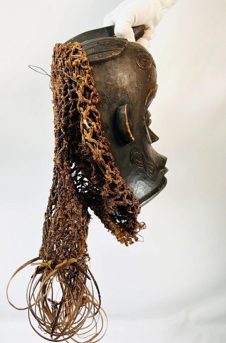 Central African Chokwe wooden mask featuring wickerwork fiber adornments