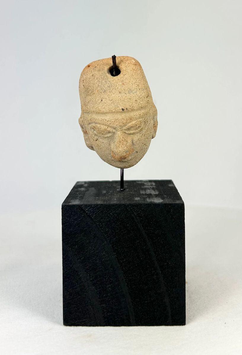 Terracotta pendant with pronounced nose lips and furrowed brow