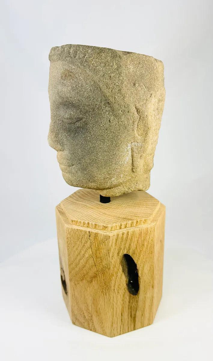 Left-side angled view of Khmer Sandstone Buddha Head Fragment from 12th-Century Angkor Period Cambodia, highlighting textured hair pattern and aged sandstone patina, mounted on wooden base – Relic and Rarity.