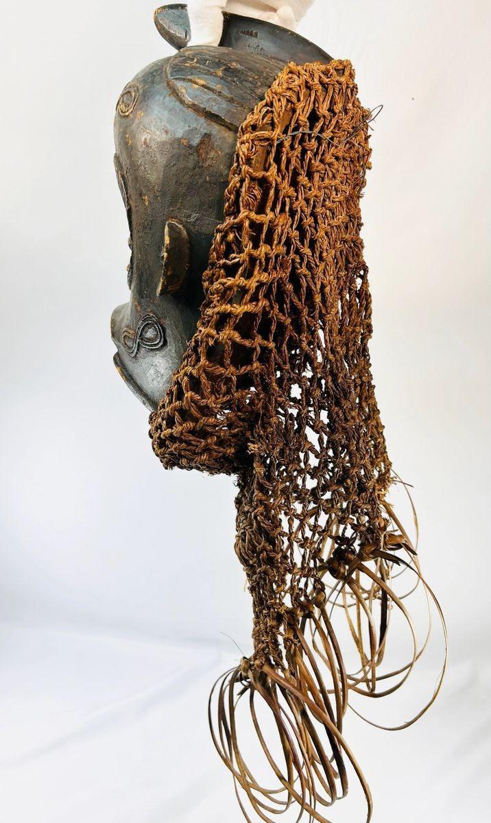 Antique Central African Chokwe mask with closed eyes and decorative fibers