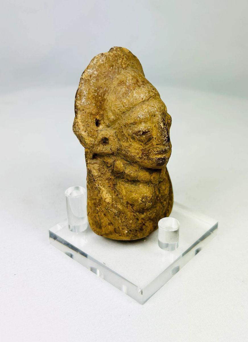 Low-angle shot of Pre-Columbian terracotta sculpture emphasizing form and age.