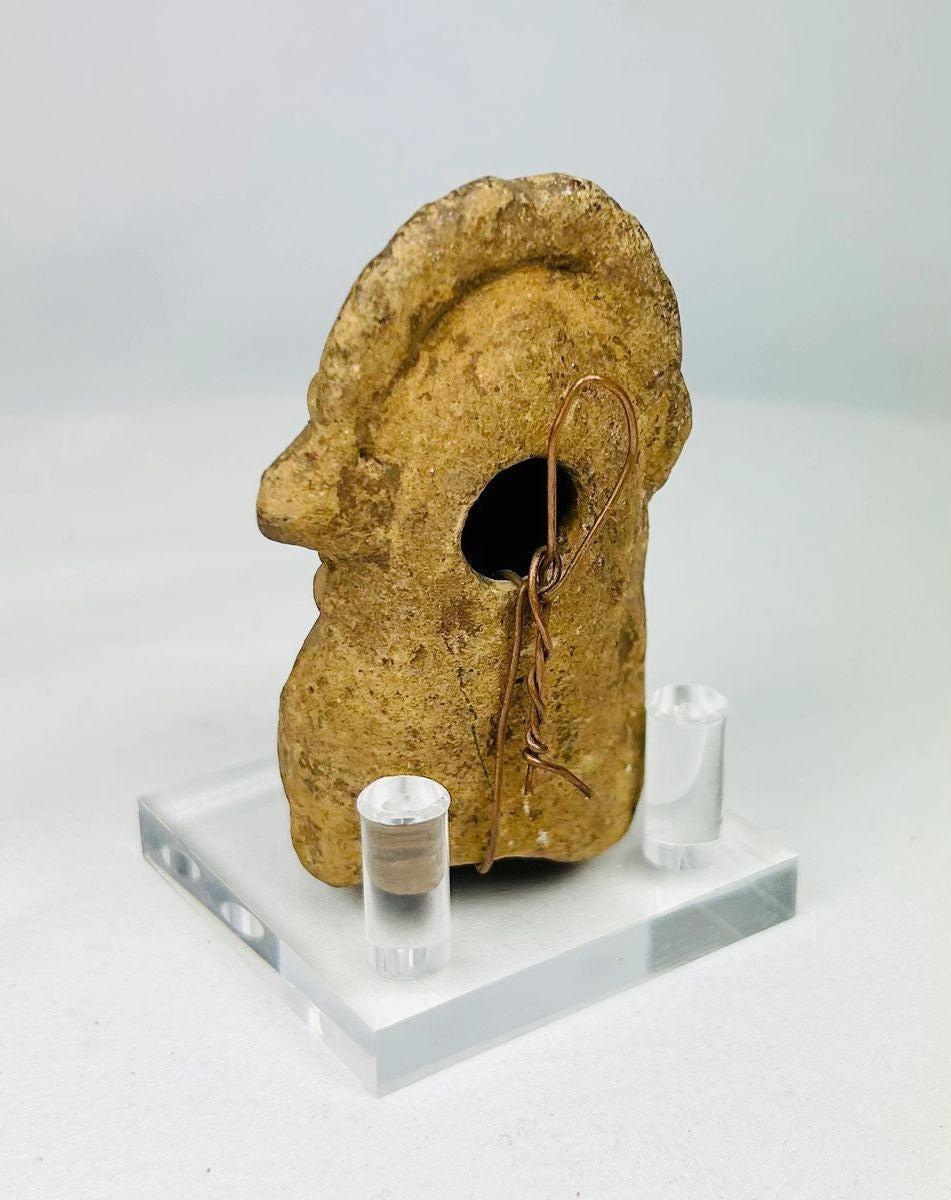 Rear angle of Mesoamerican terracotta sculpture showing sculpted headdress details.