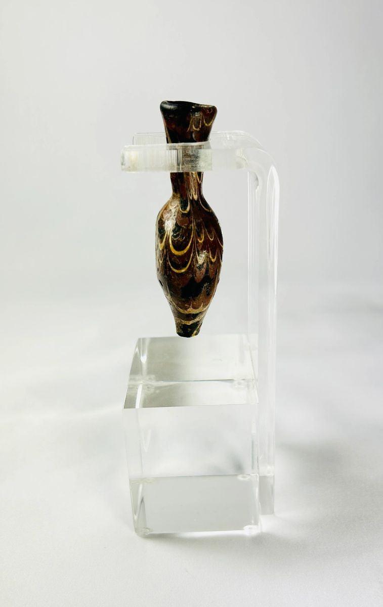 Glass alabastron decorated with marbled browns yellows and gold trailing