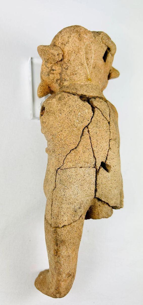 Rear view of a Mesoamerican ceramic figurine displaying hand-modeled form and age wear