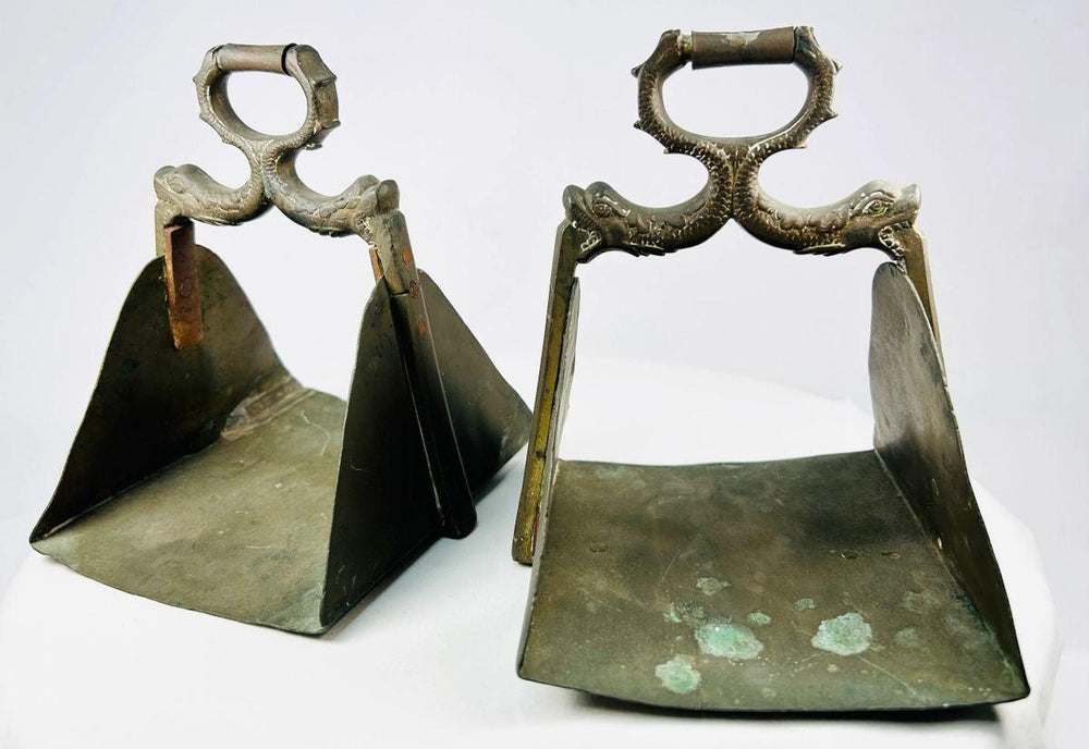 Heavy antique stirrups featuring detailed craftsmanship and natural patina