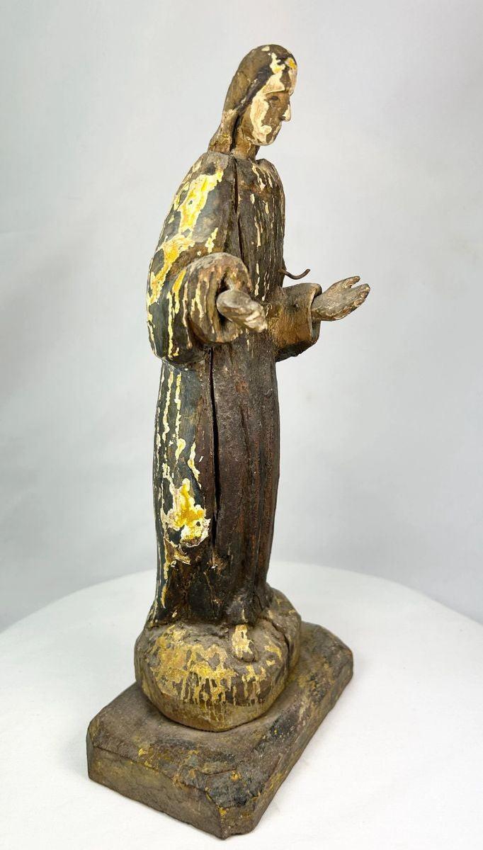 Side profile of a Spanish Colonial santo religious statue carved in wood with visible patina