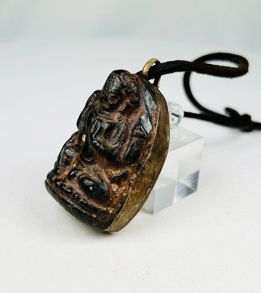Antique Tibetan/Nepalese bronze Buddha amulet pendant, circa 1880–1920, with shrine-style niche, sealed brass back, original leather cord, and aged patina. Traditional devotional reliquary used for spiritual protection and meditation.