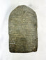 Rear view of a 14th-century Tibetan stone stele showing natural wear and carving marks