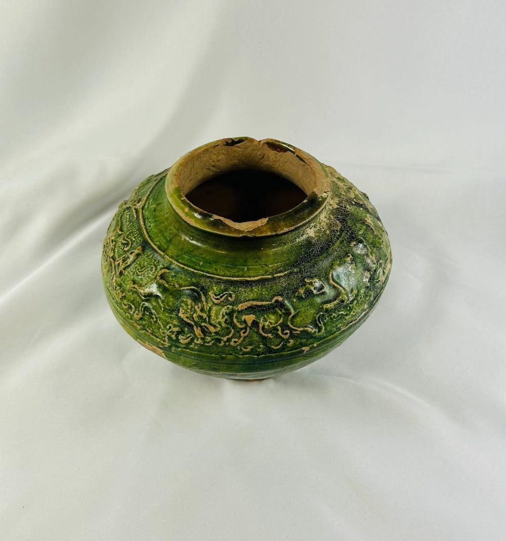 Ancient Han Dynasty green-glazed pottery vessel with molded human and animal motifs.