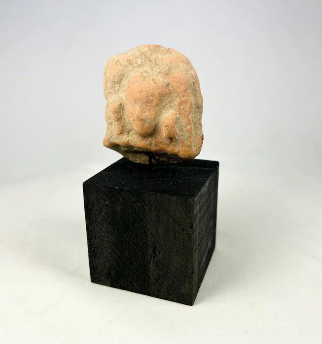 Ancient Gandharan terracotta male bust plaque photographed on white background