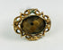 Victorian mourning hairwork brooch with braided human hair beneath beveled glass, mid-19th century.