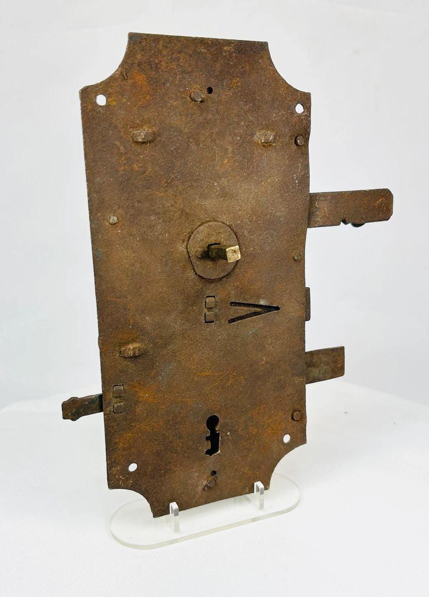 Antique forged iron door lock with visible internal mechanism and scroll springs