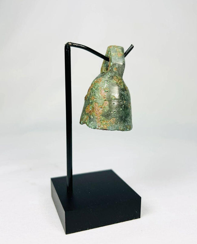 Side view of ancient Roman ritual bell highlighting its rounded body and cast bronze construction.