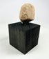Side profile view showing sculpted hairstyle on a terracotta head fragment