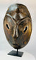 Macro view highlighting wood grain and carved texture on a Sepik River mask