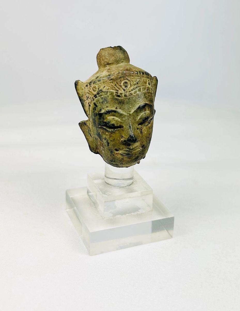 Close-up detail of serene facial expression on a bronze Buddha head