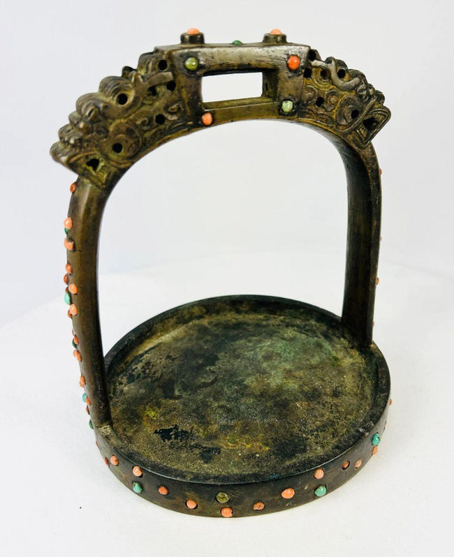 Angled top view highlighting pierced arch and inlaid coral-turquoise beads on saddle stirrup.