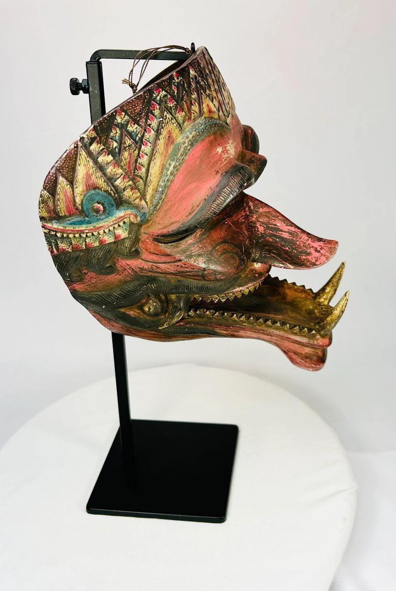 19th-century Indonesian Cakil theatrical mask shown from an angled perspective on a museum-style stand.