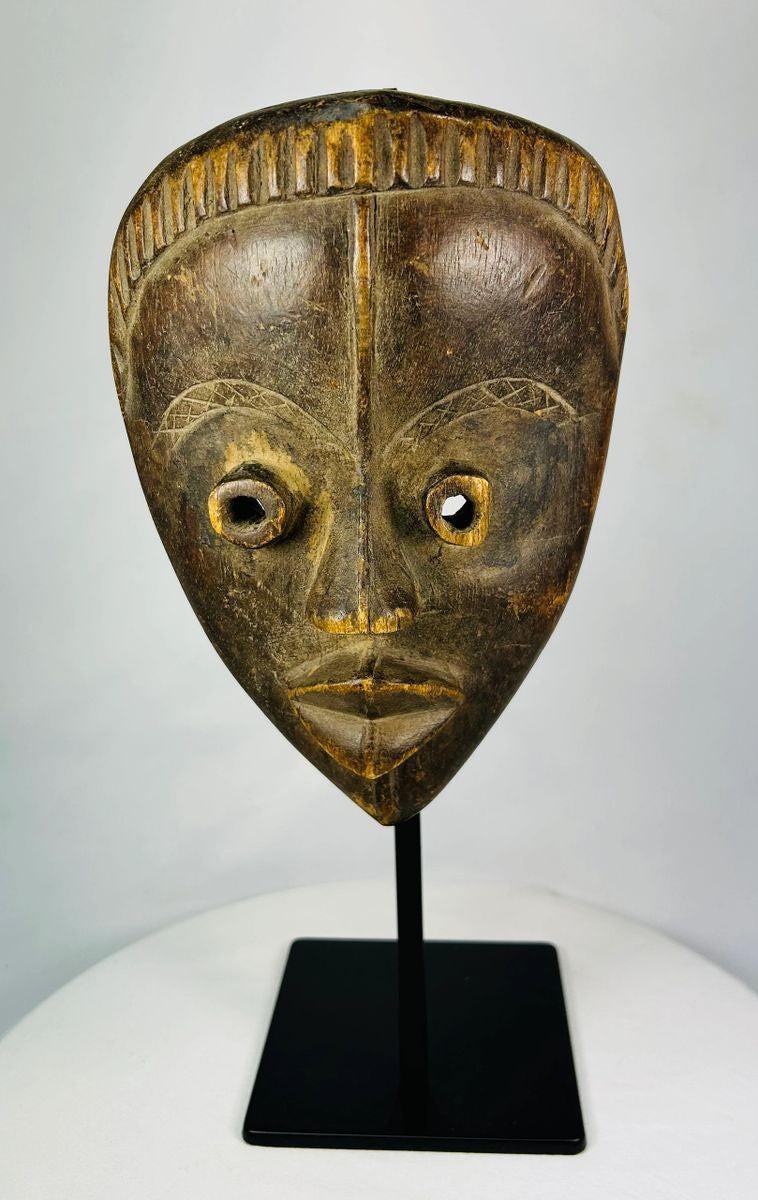 West African Baule ceremonial mask with incised scarification and refined symmetrical expression