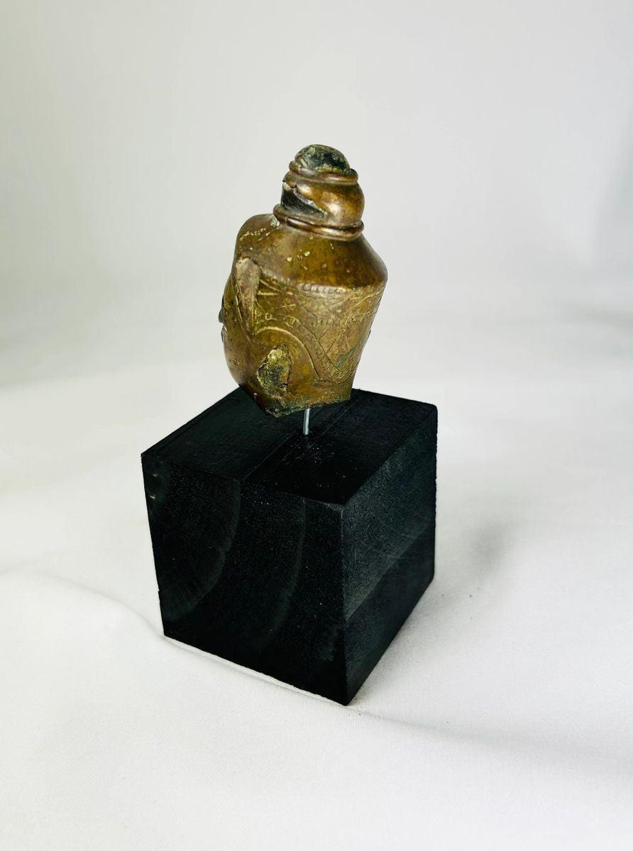 Antique Southeast Asian bronze Buddha head, 18th–19th century CE, pointed ushnisha, greenish patina, displayed on black base