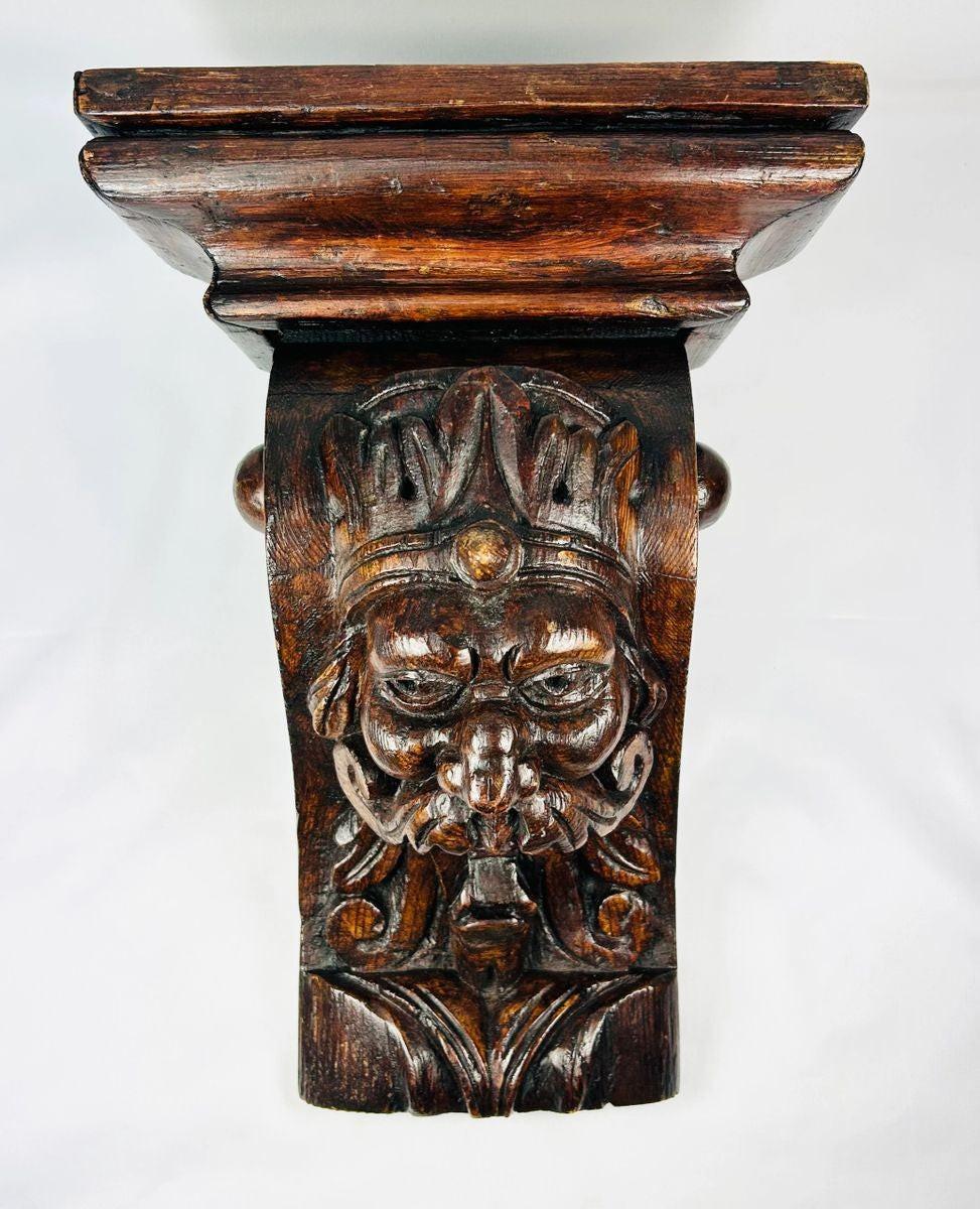 Antique hand-carved wooden corbel with grotesque face and historic craftsmanship