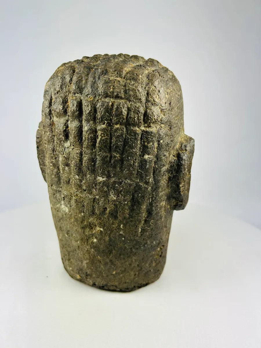 Rear view of a weathered Polynesian basalt stone head sculpture from the 18th–19th century.