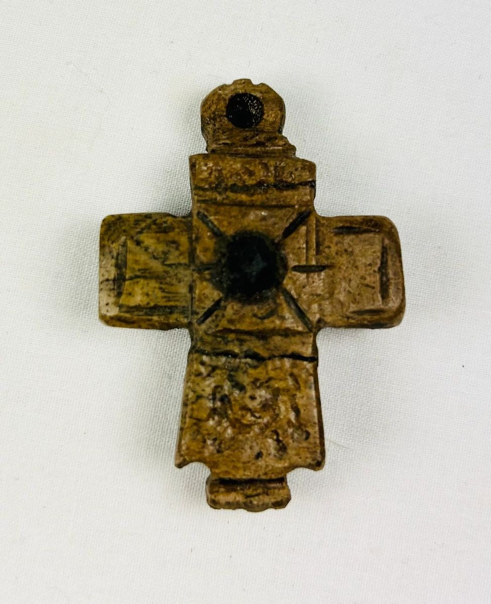 Ancient Byzantine carved bone cross pendant, incised with cross motif and central raised boss, worn devotional artifact, circa 900–1200 AD.