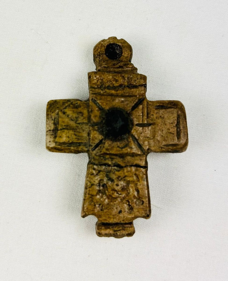 Ancient Byzantine carved bone cross pendant, incised with cross motif and central raised boss, worn devotional artifact, circa 900–1200 AD.