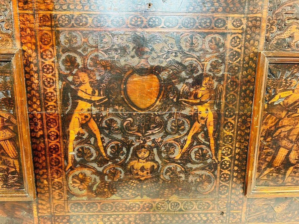 Close-up of a 16th-century carved wooden panel featuring hunters, horses, and decorative Renaissance borders.