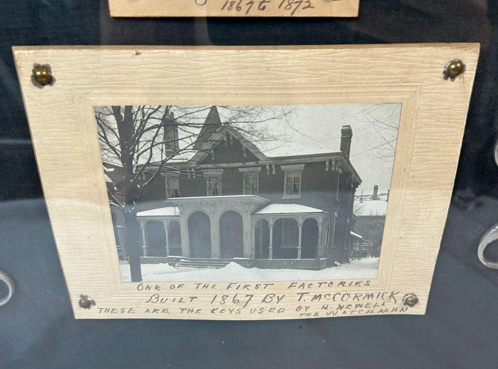 Antique iron keys in wooden shadowbox with historical photograph