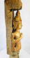 Tall Myanmar temple finial displaying Buddha in prayer gesture and traditional spire form
